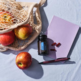 dōTERRA Adaptiv Nahrungsergänzung – Flasche mit Äpfeln, Beutel und Notizbuch in Rosa, Vogelperspektive | doTERRA