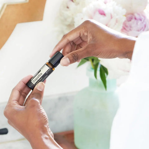 dōTERRA Copaiba Touch Roll-On 10ml – Dunkle Hände mit Pfingstrosen und Rosen | doTERRA
