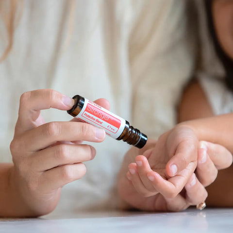dōTERRA Stronger Roll-on 10ml – Anwendung auf Hände eines Jungen für Immunstärke und Wohlbefinden | doTERRA