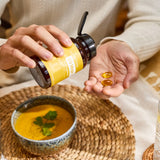 dōTERRA EO Mega Softgels – Flasche und Softgels in Händen mit Schüssel und Suppe | doTERRA