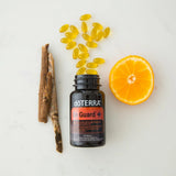 dōTERRA On Guard Plus Softgels – offene Flasche auf orangem Marmor | doTERRA