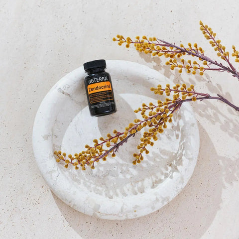 dōTERRA Zendocrine Softgels schwarze Flasche auf Marmorteller mit getrockneten Zweigen | doTERRA